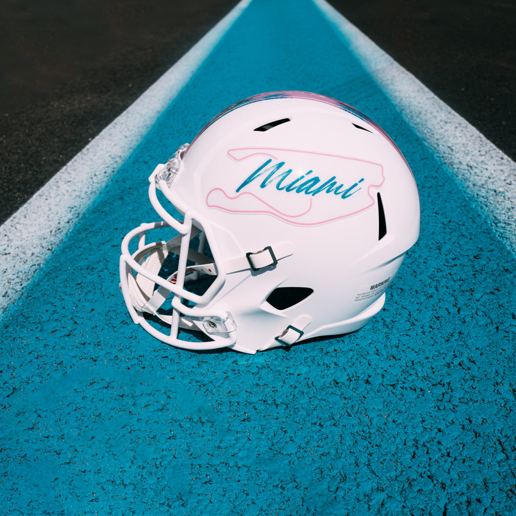 white MIA full size replica football helmet with pink track and aqua "Miami" lettering on the helment